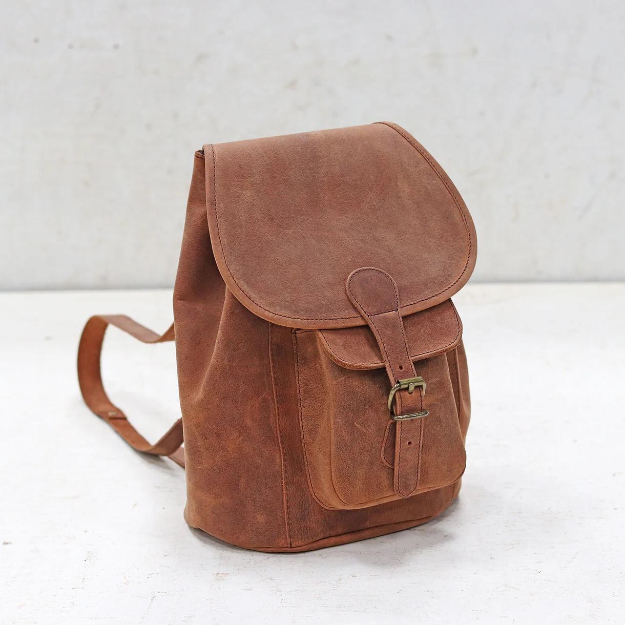 A mini brown leather backpack with vintage-style brass buckles.