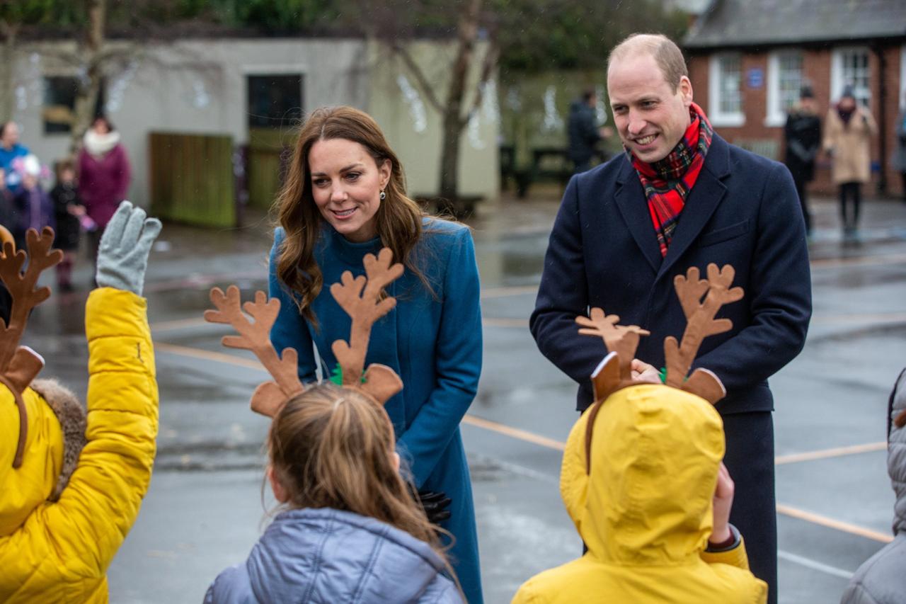 Kate Middleton and Prince William meet with school children wearing reindeer ears