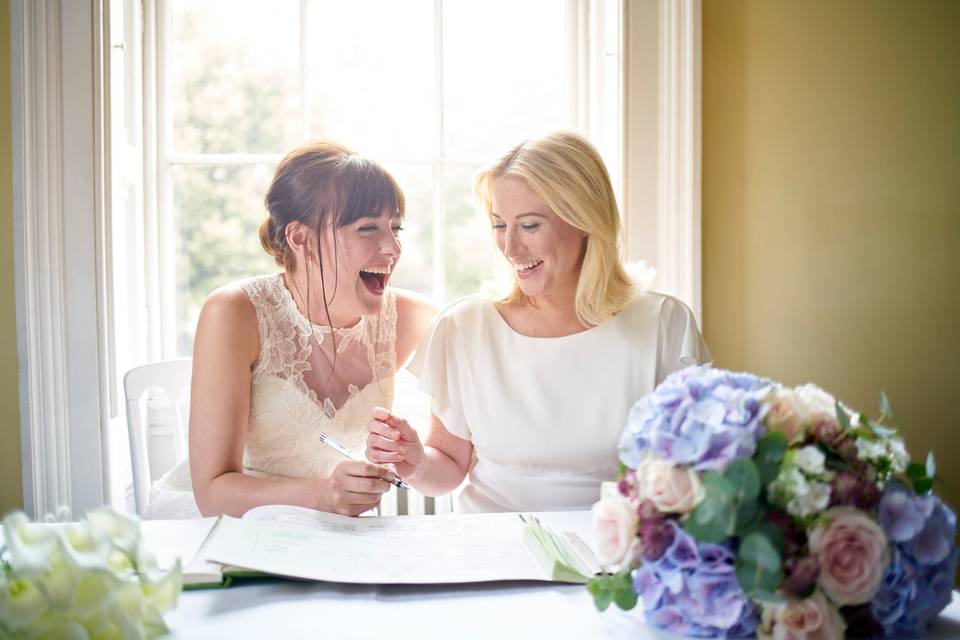 Two brides signing the wedding register