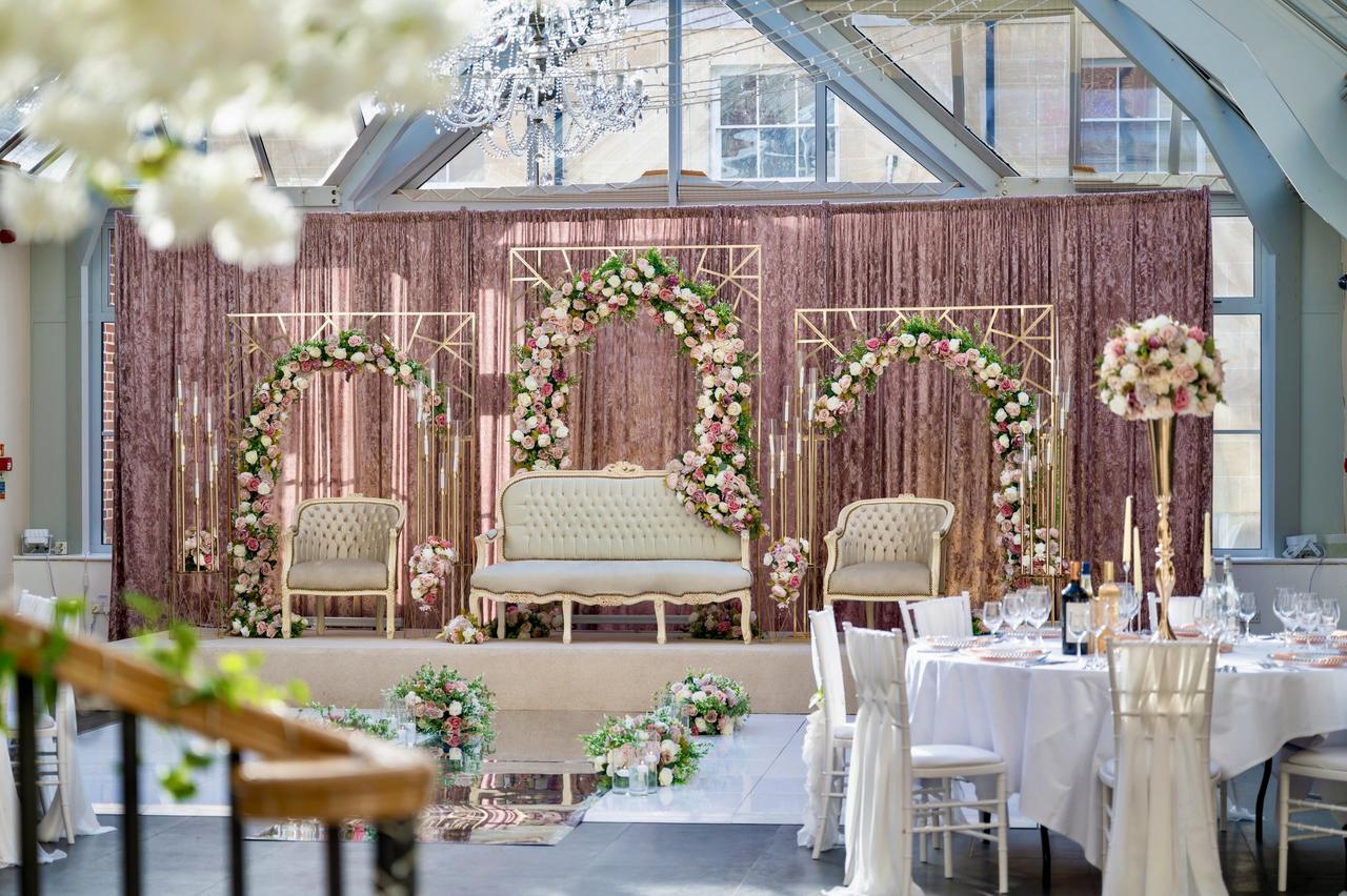 A stage area set up for an Asian wedding in a conservatory.