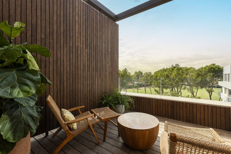 Balcony with two chairs, plant and view over trees