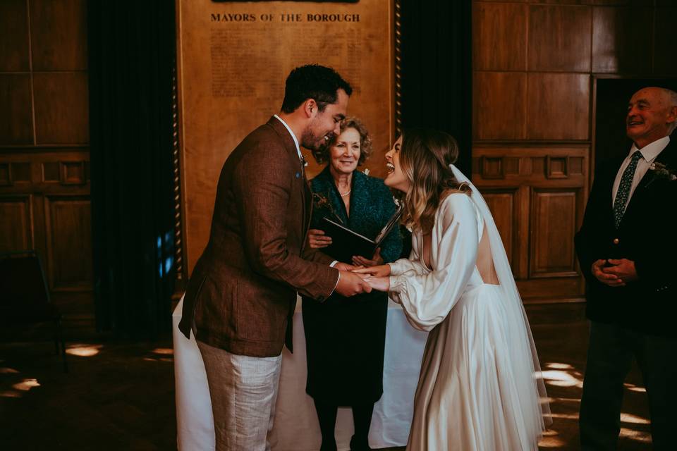 A bride laughing and beaming as she hears a love poem for her