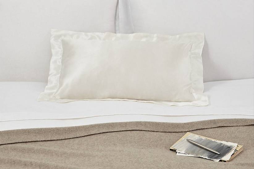 Cream silk pillowcase displayed on a bed as a 12th wedding anniversary gift