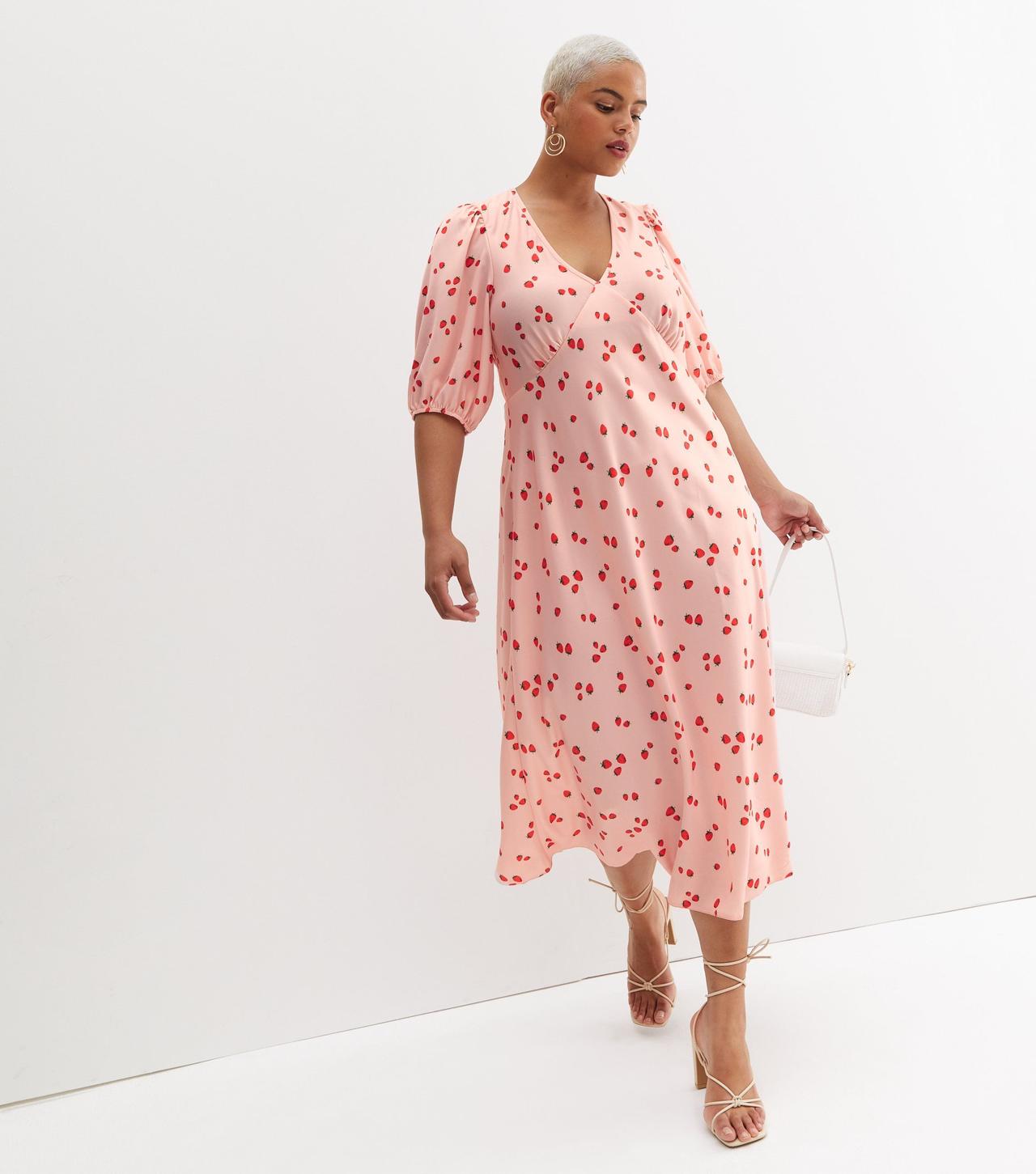Model wearing a pink strawberry print wedding guest dress