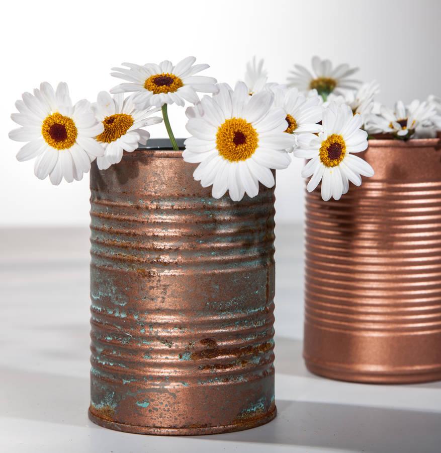 tin vase in a copper shade filled with daisies