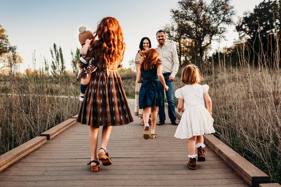 Blended family with four children running towards their parents in an outdoor setting