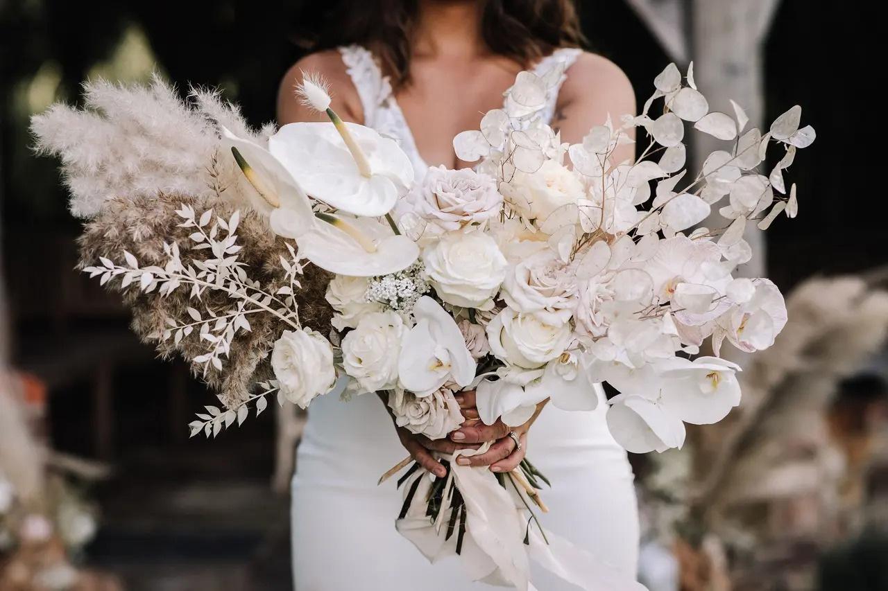 Bride holding a chic white rose wedding bouquet