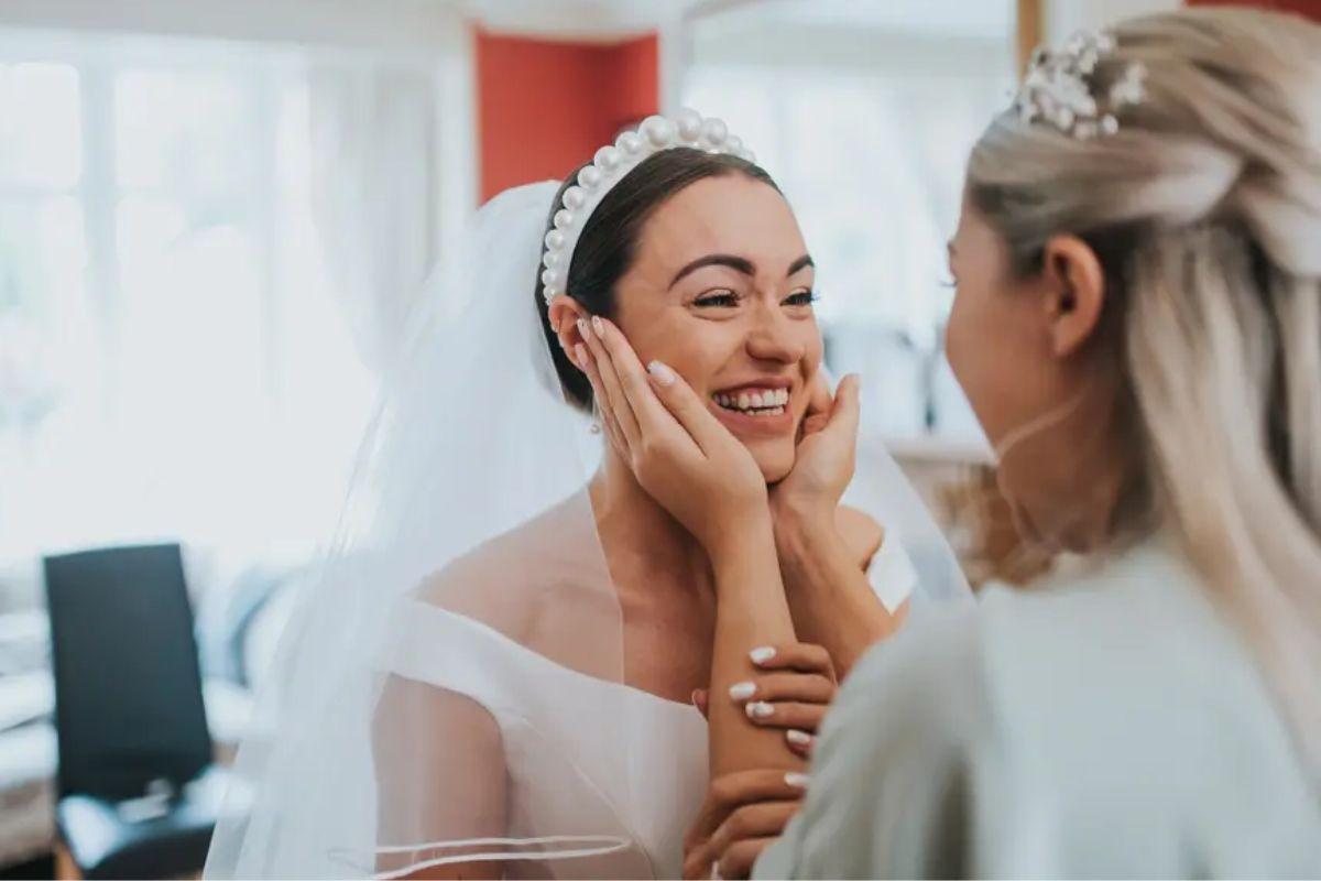 Bridesmaid holding a bride's face on her wedding day