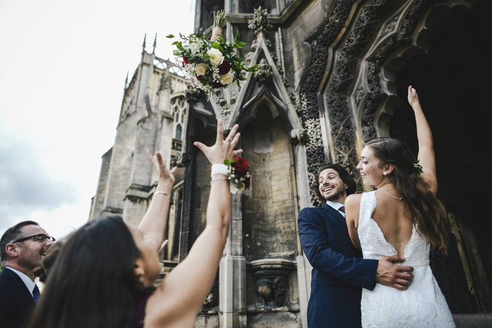 Bride tossing her bouquet to wedding guests