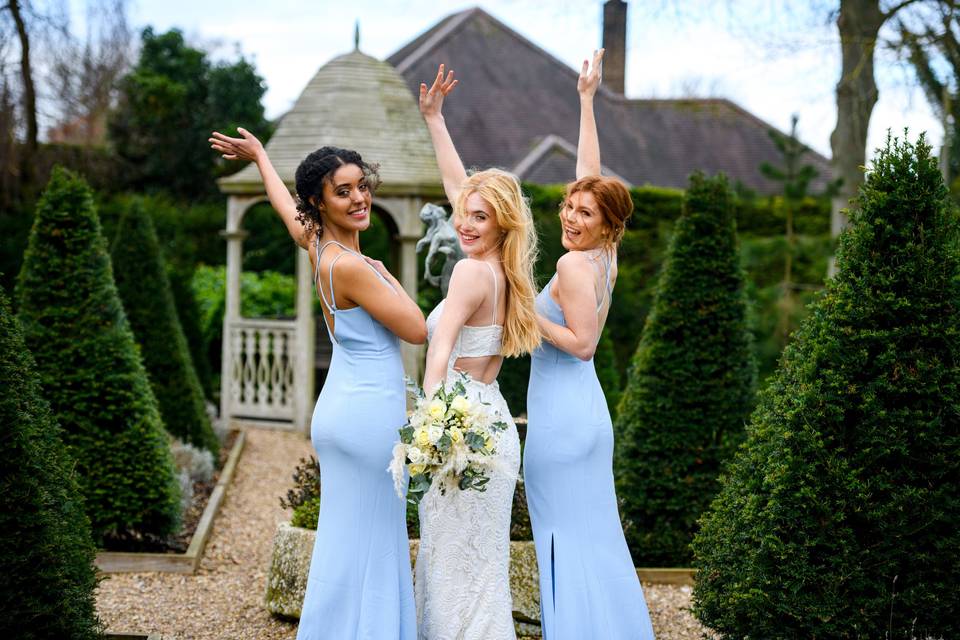 Bride in a rented wedding dress with a bridesmaid posing either side of her