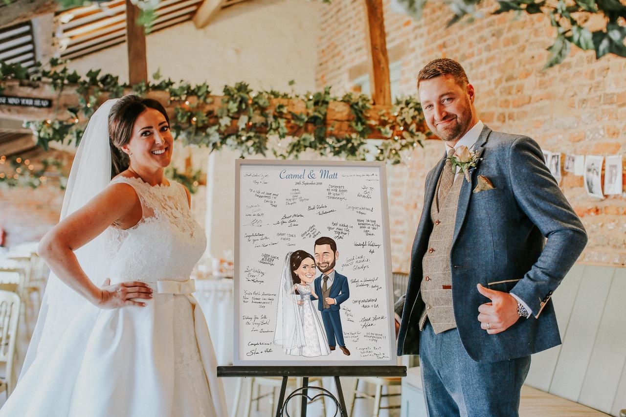 Bride and groom standing next to a caricature guest book