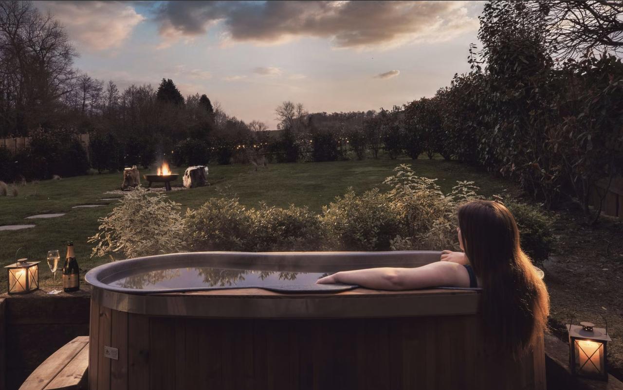 Hot tub outside of a cabin with a woman reclining in it