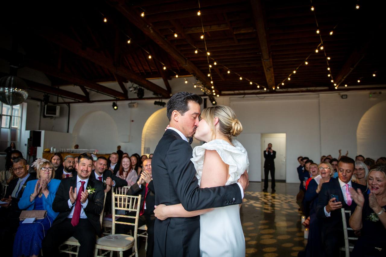 A bride and groom kiss during their wedding ceremony