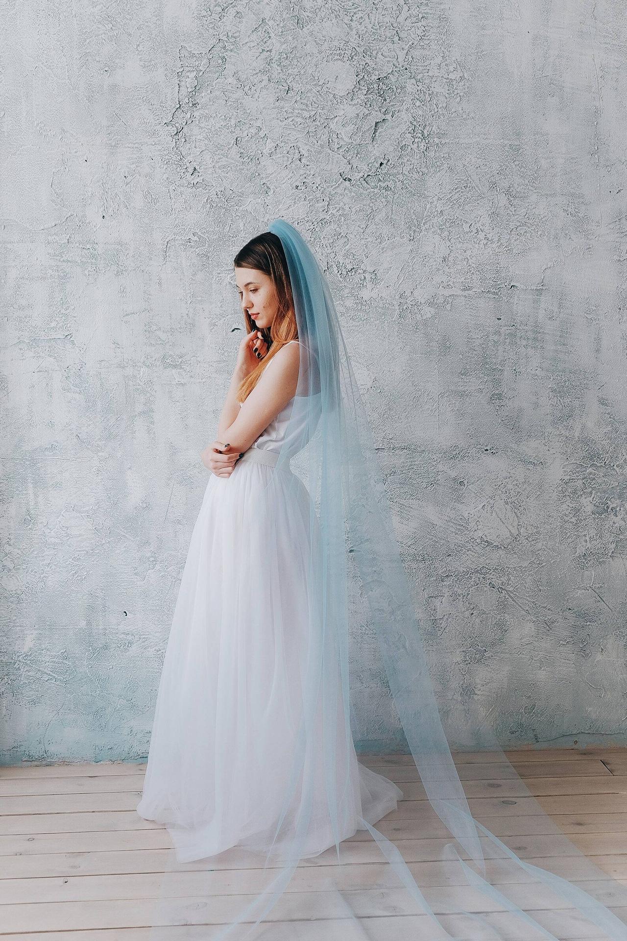 White bride with copper ombre hair wearing a white tulle skirt, silky white camisole and a sky blue sheer tulle veil