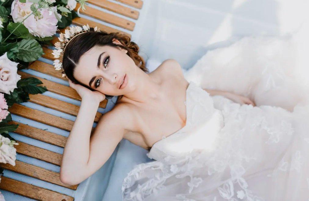 Bride wearing leafy crown with bold brows and lined eyes