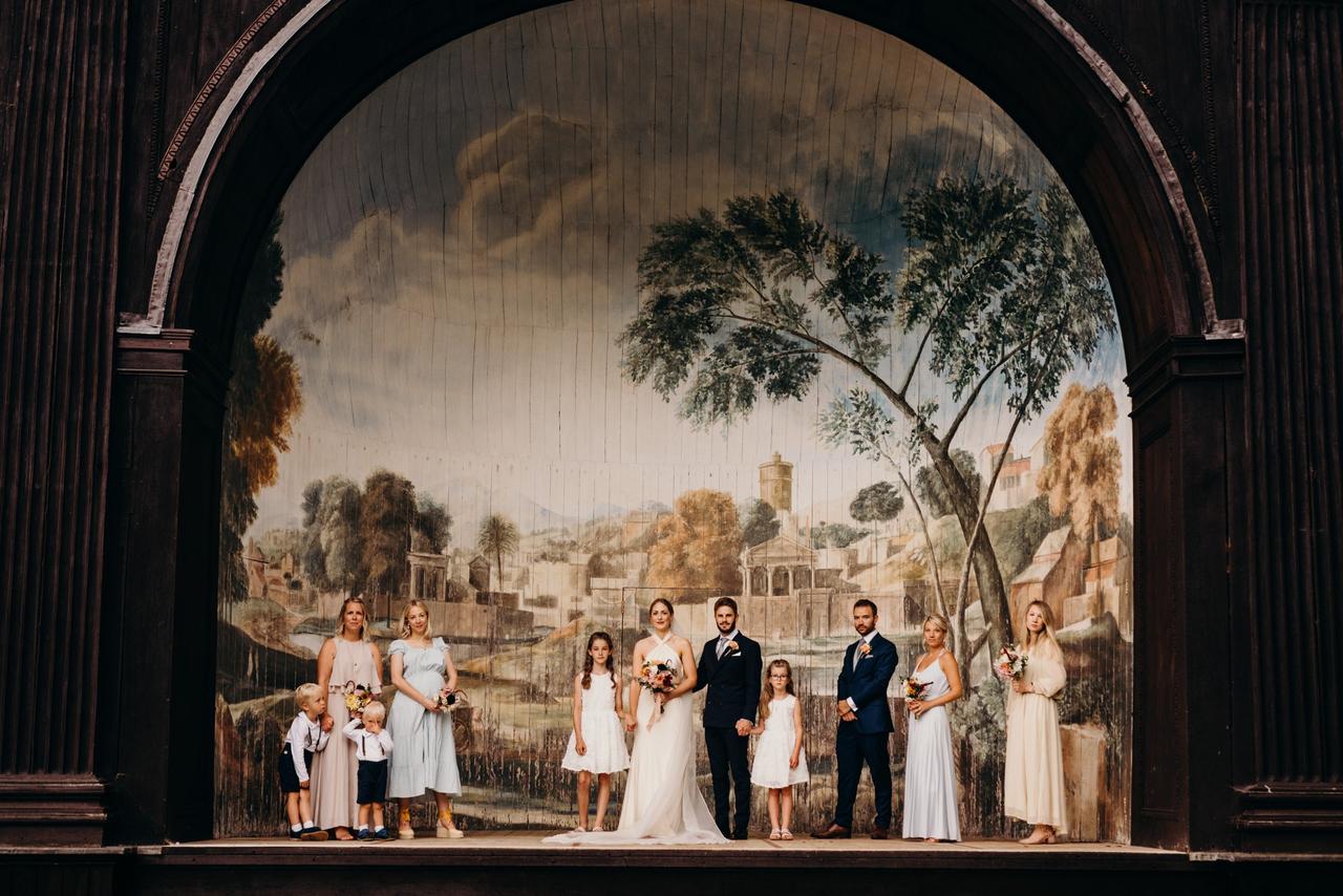 Bride, bridesmaid and groomsmen standing next to a moasic