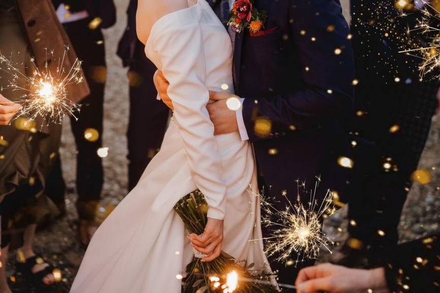 Bride and groom kissing with sparklers