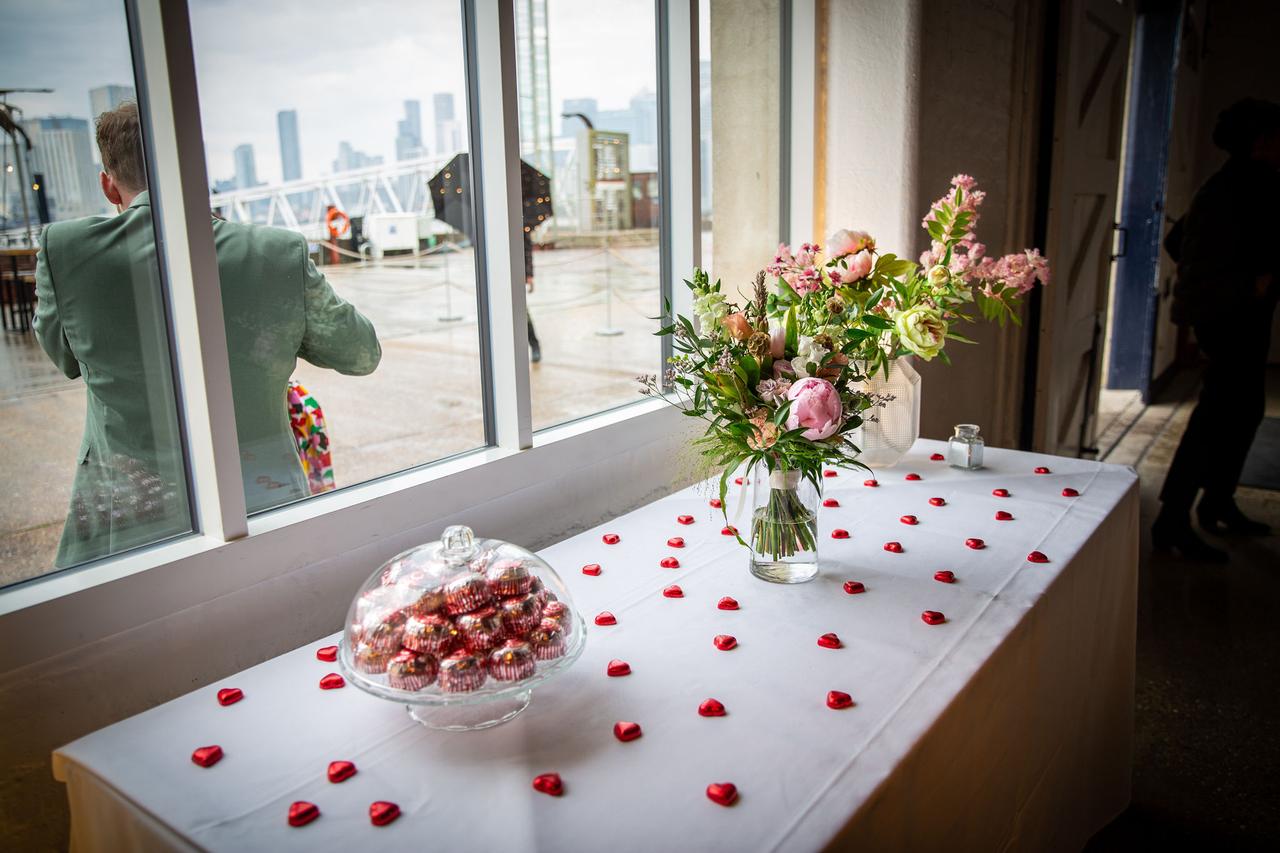 A table with red heart chocolates, flowers and a tower of Tunnock's teacakes