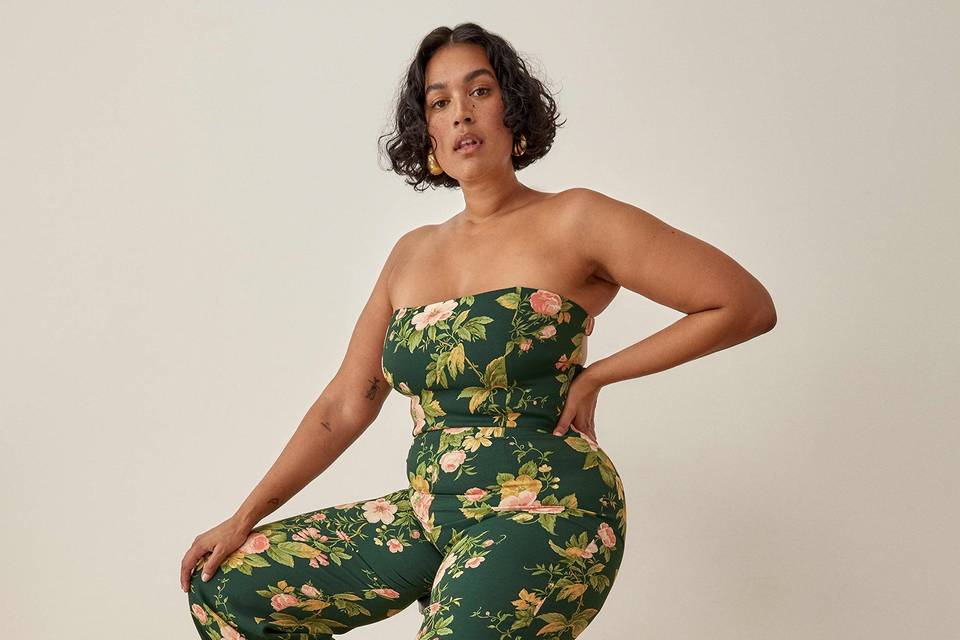 woman wearing a strapless green floral wedding guest jumpsuit