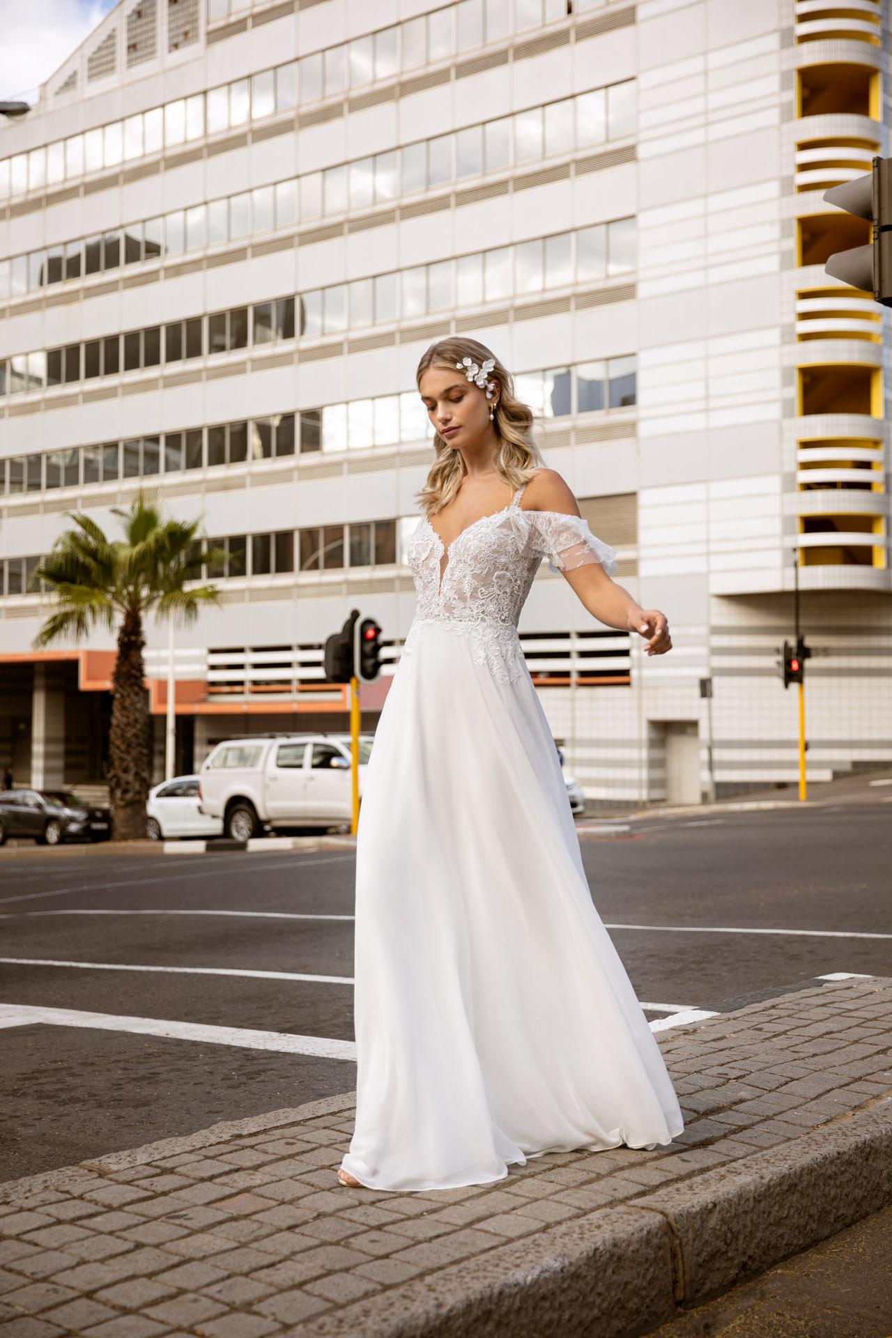 Bride wearing an off the shoulder angel sleeve wedding dress