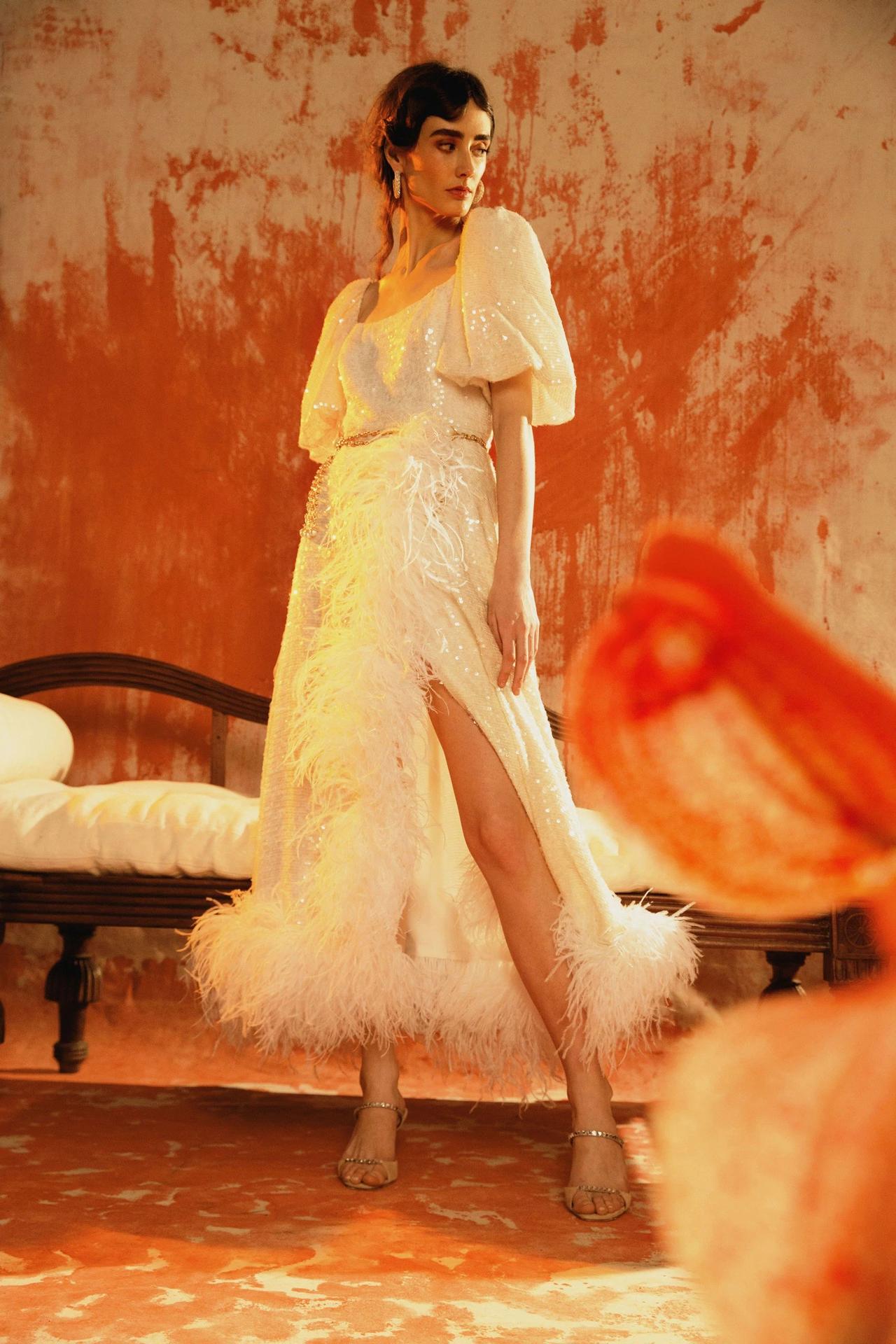 Model wearing a feather, sequin and puff sleeve wedding dress