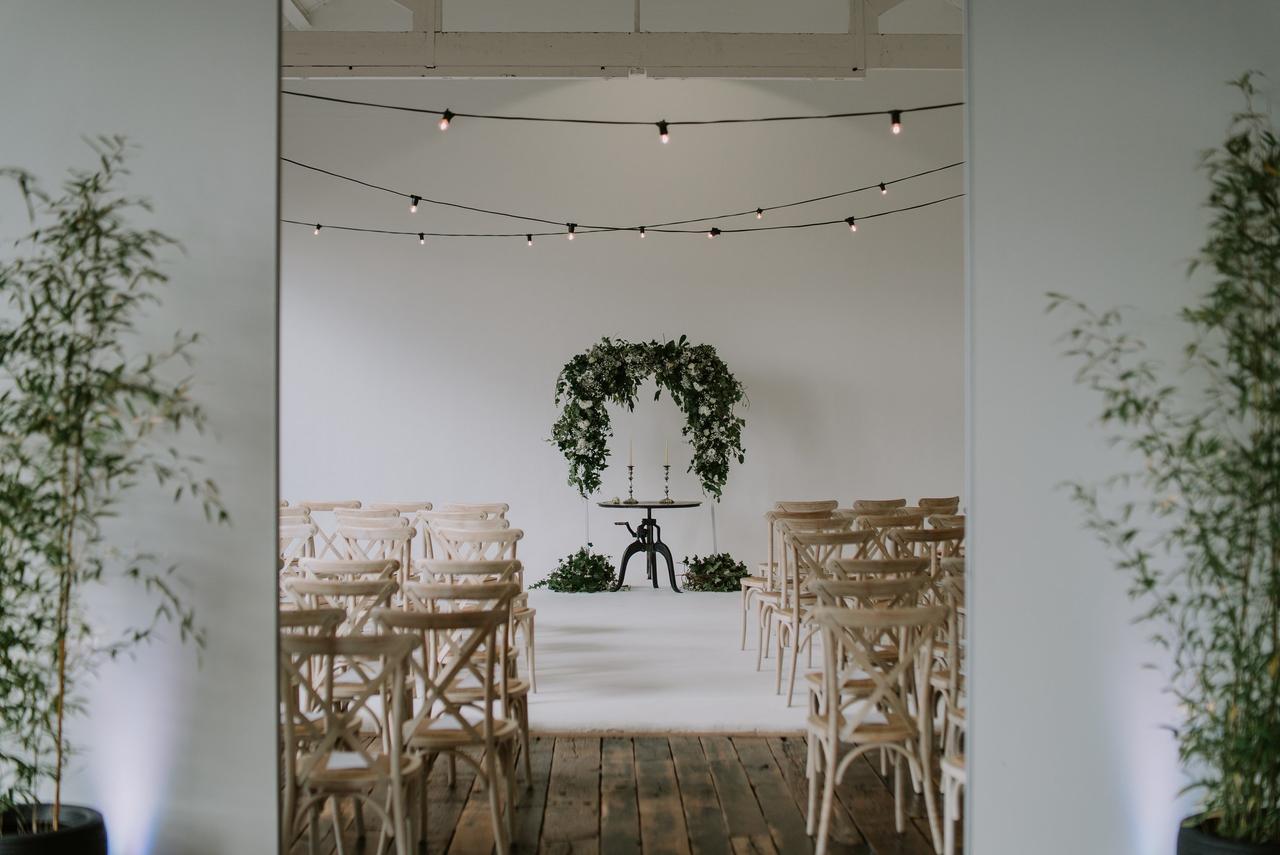 The wedding ceremony room with floral arch and festoon lights