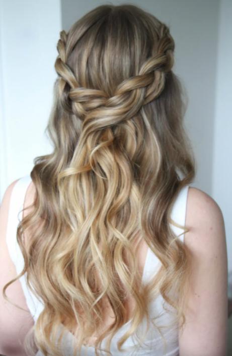 A blonde with long wavy hair and two plaits woven together at the top