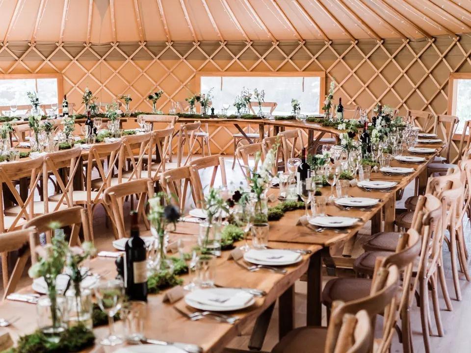 Wooden wedding tables in a marquee