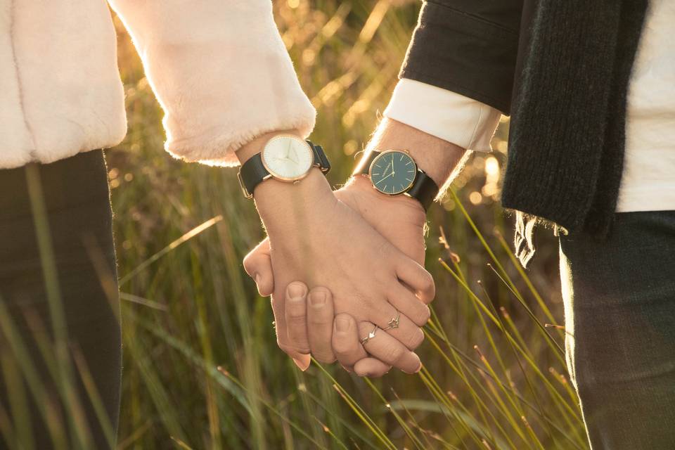 Couple wearing watches hold hands