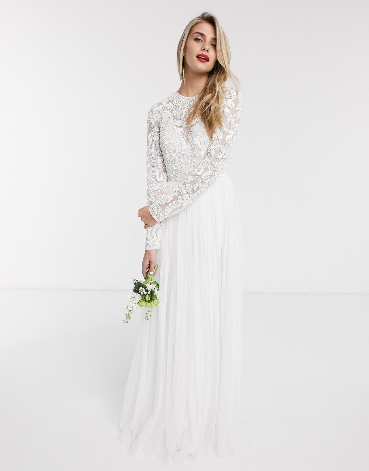 Model wearing an embellished long sleeved wedding dress