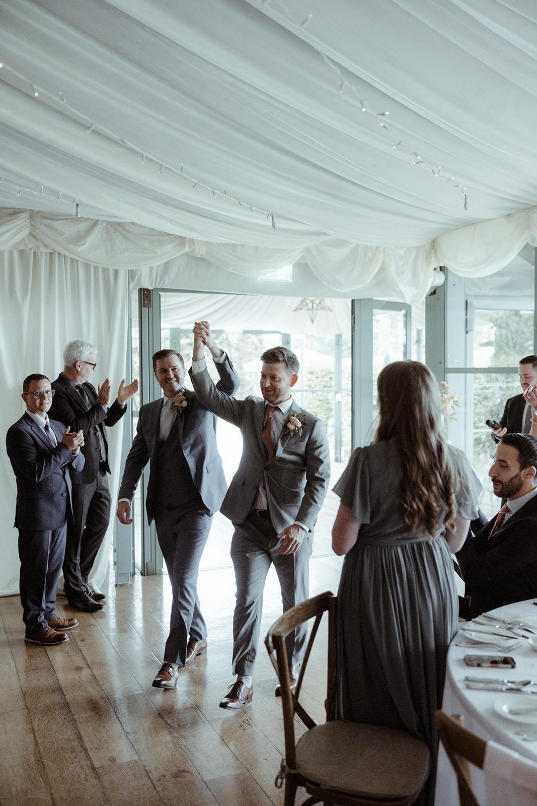 The couple enter the reception as guests clap