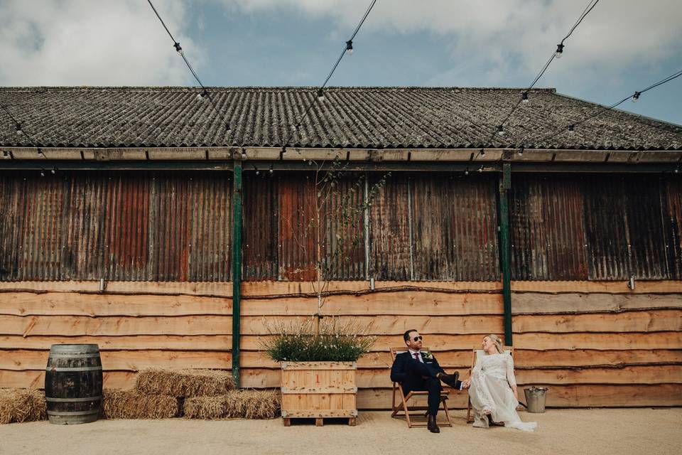 Newlyweds lounge in the sun outside the rustic Huntsmill Farm.