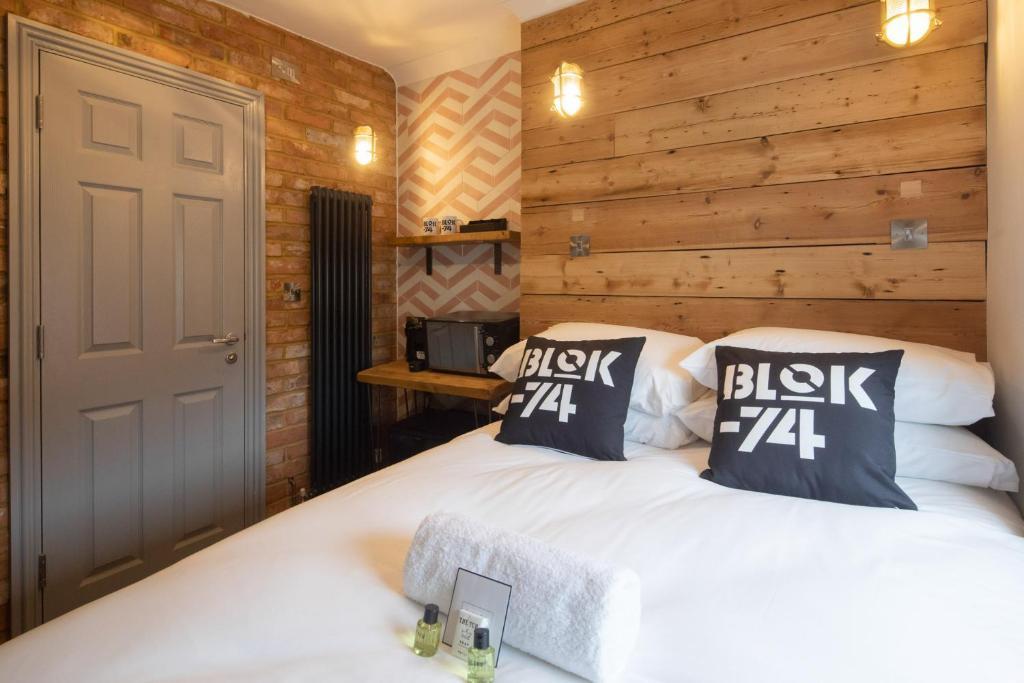 a small cosy room at brighton hen do hotel with a double bed, white linen and a light oak panelled wall