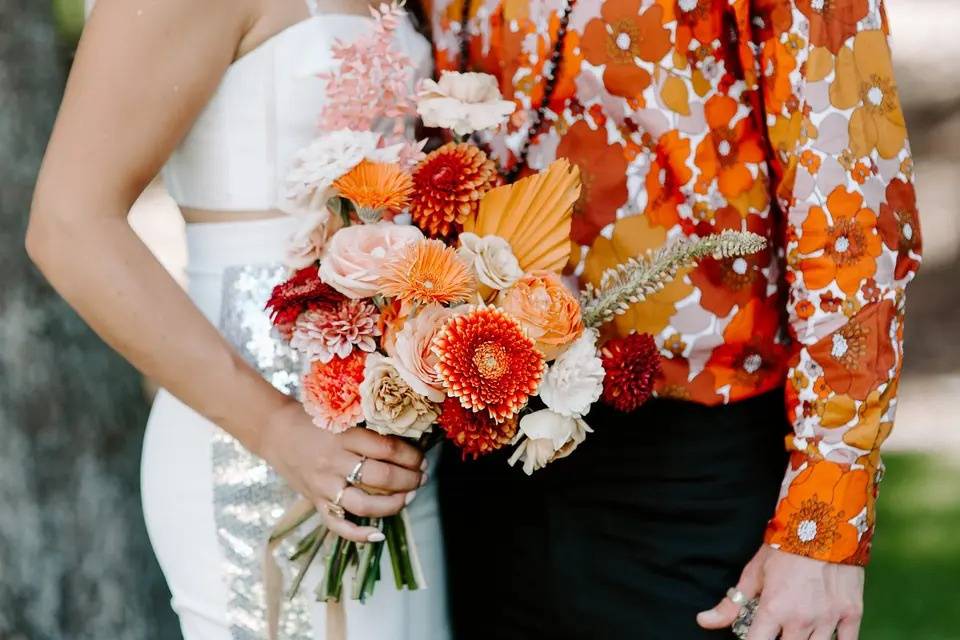 Couple holding orange vintage wedding flowers