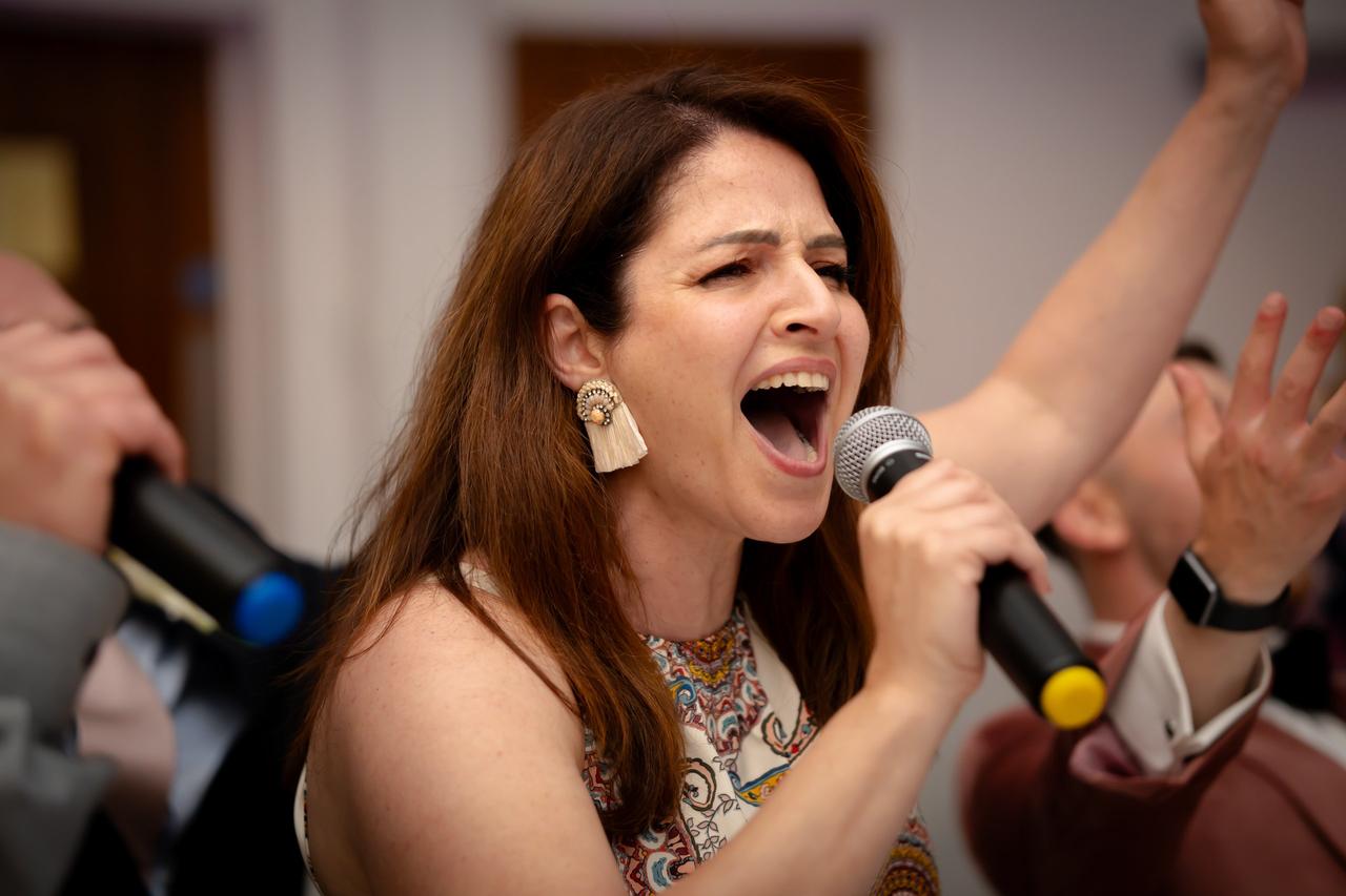 Wedding guest singing into a microphone at wedding karaoke