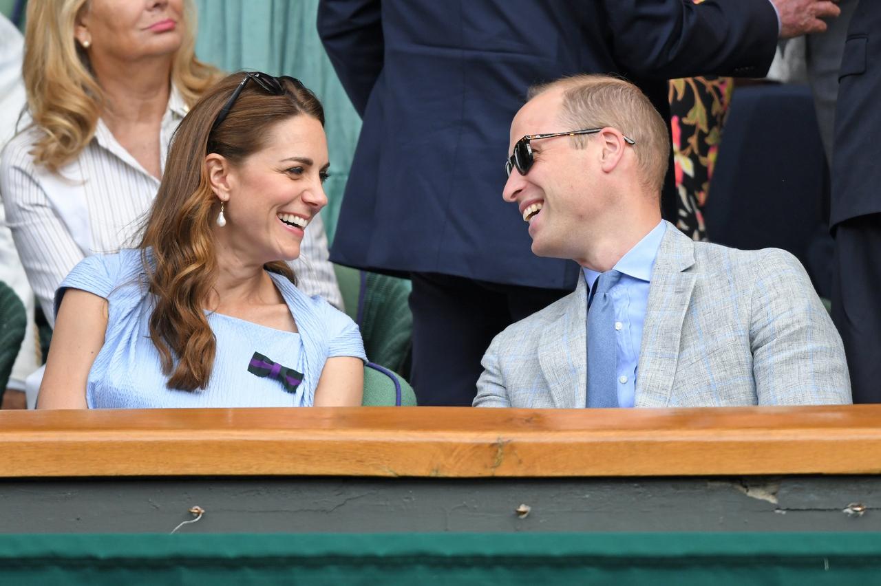Kate Middleton and Prince William laughing while watching tennis