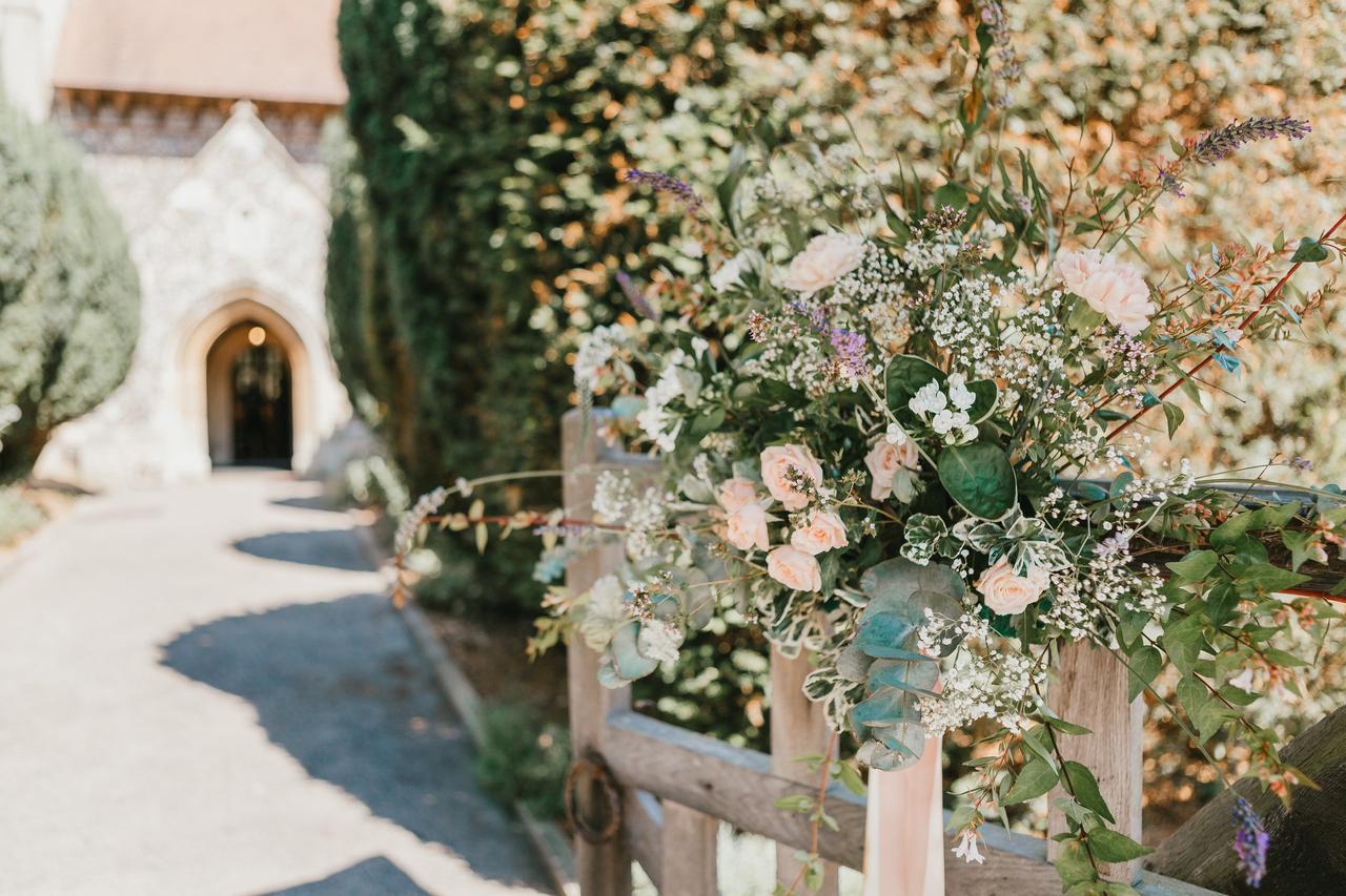 A church gate adorned with blush pink flowers