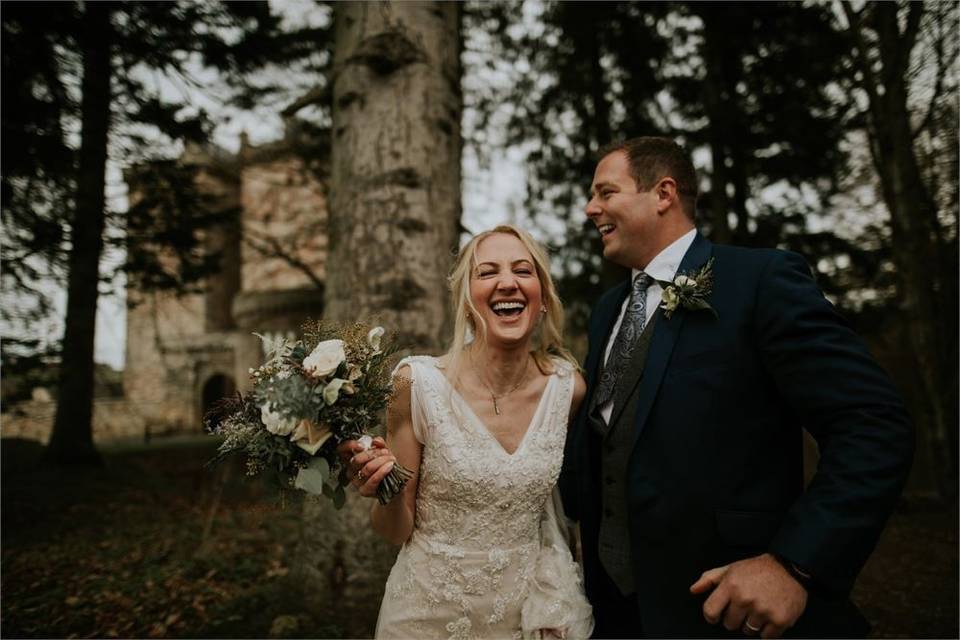 Bride and groom laughing outside a castle wedding in Scotland