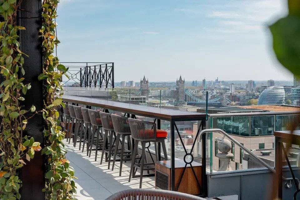 Bar stools and bar on rooftop terrace with great views of the city of London and Tower Bridge