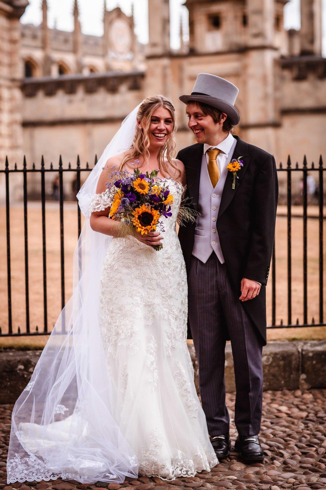 The bride and groom stand together and smile