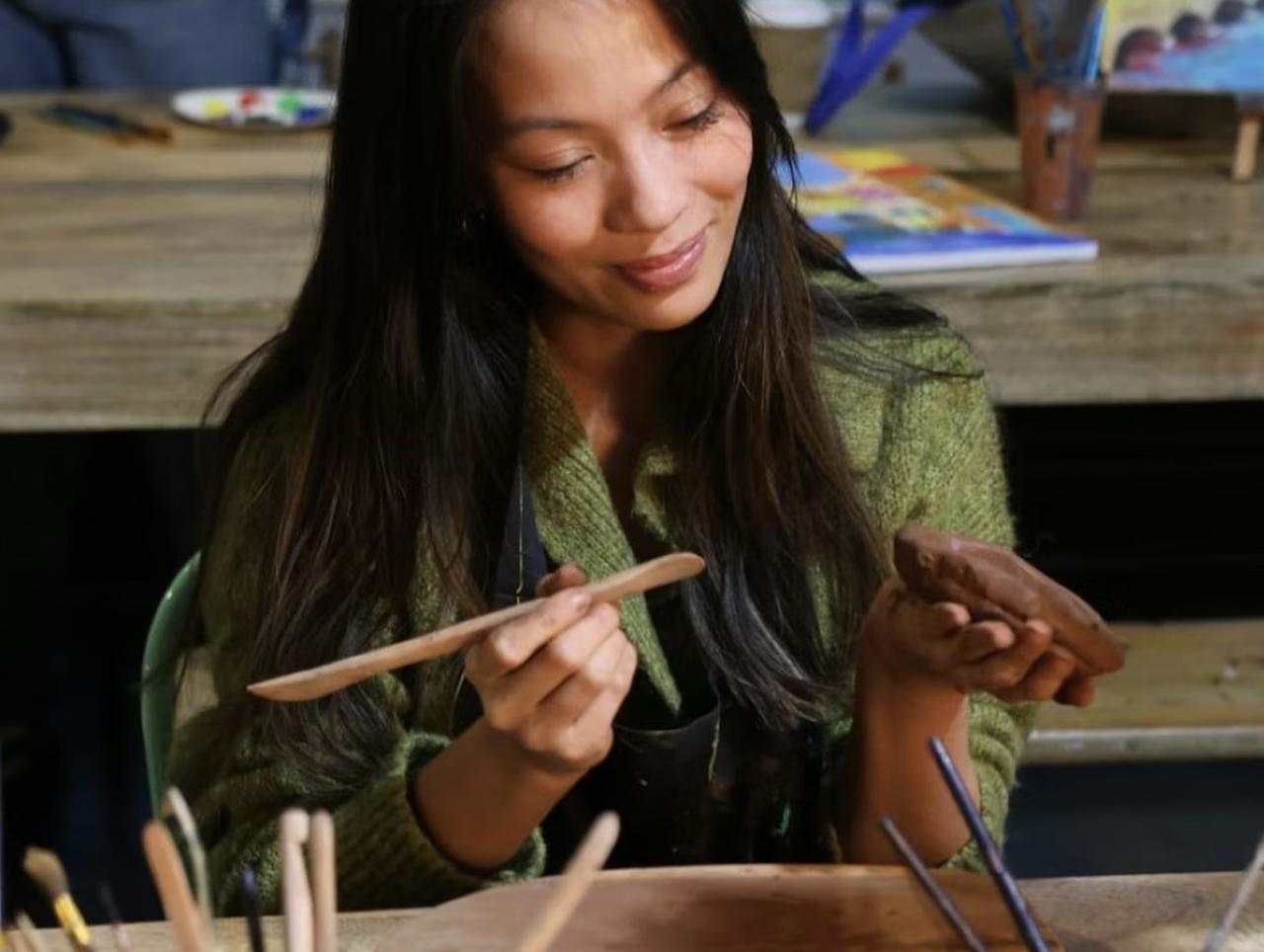 woman forming a clay plate in a pottery studio