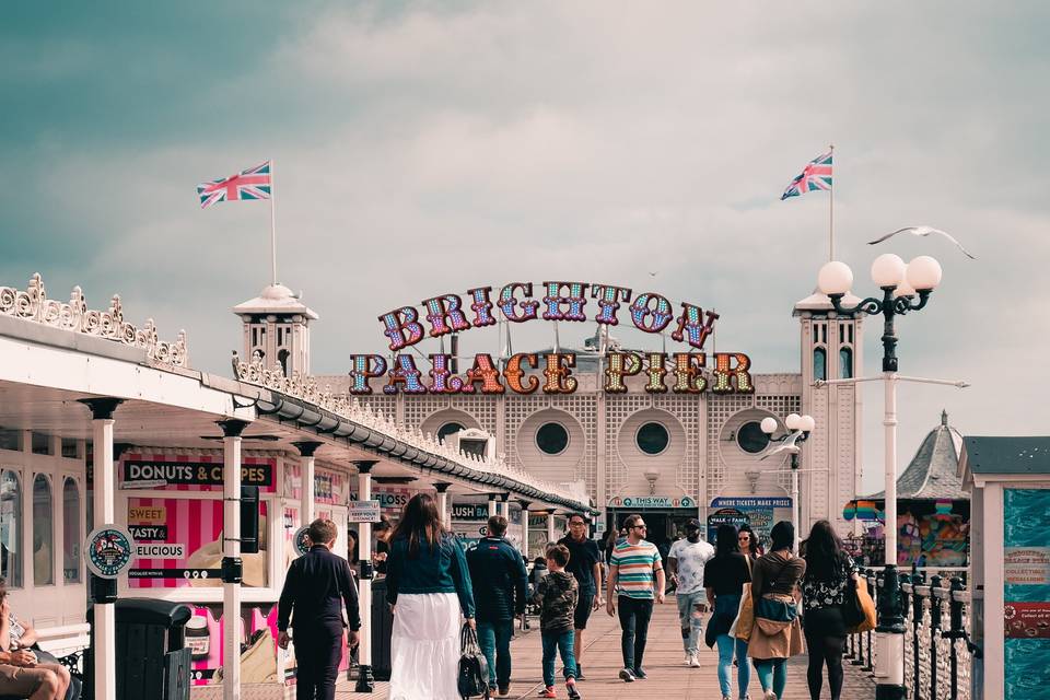 a group of people walking up and down Brighton Palace Pier 