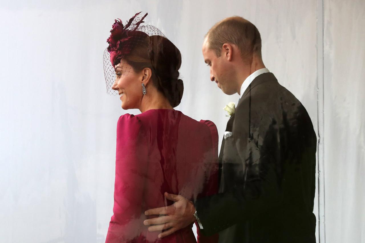 Prince William puts his hand on the back of Kate Middleton