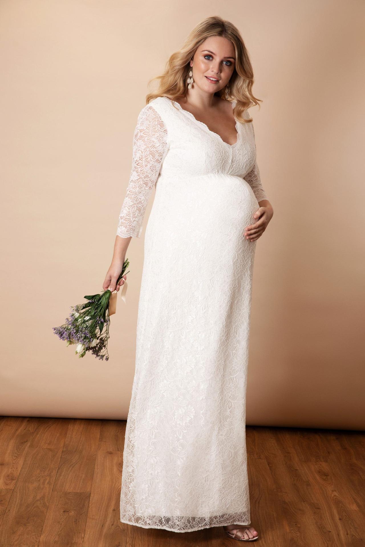 Model wearing a lace maternity long sleeved wedding dress