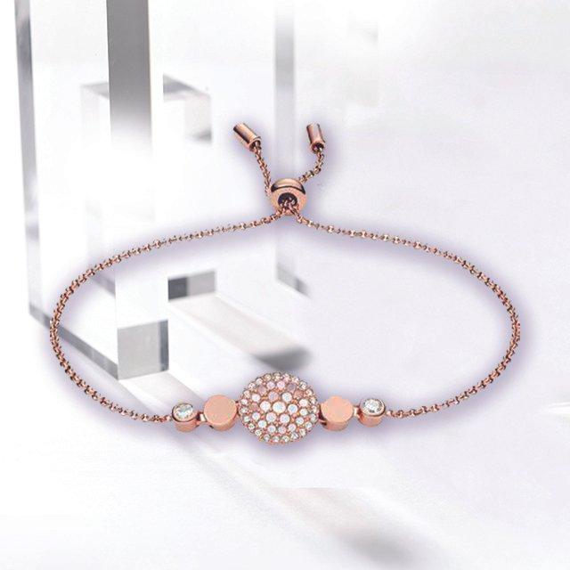 Rose gold friendship bracelet with a disc at the centre that's studded with mother of pearl