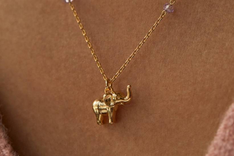 A close up of a gold elephant necklace for a 14th wedding anniversary gift that is both modern and traditional