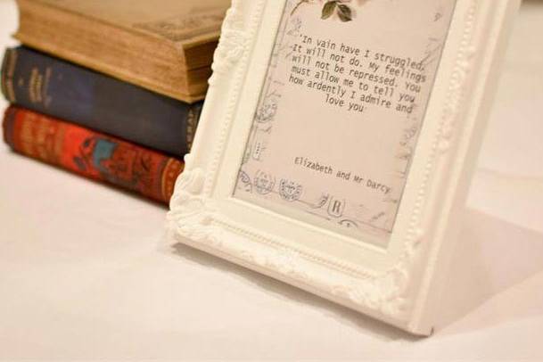 Stack of books next to an antique white frame