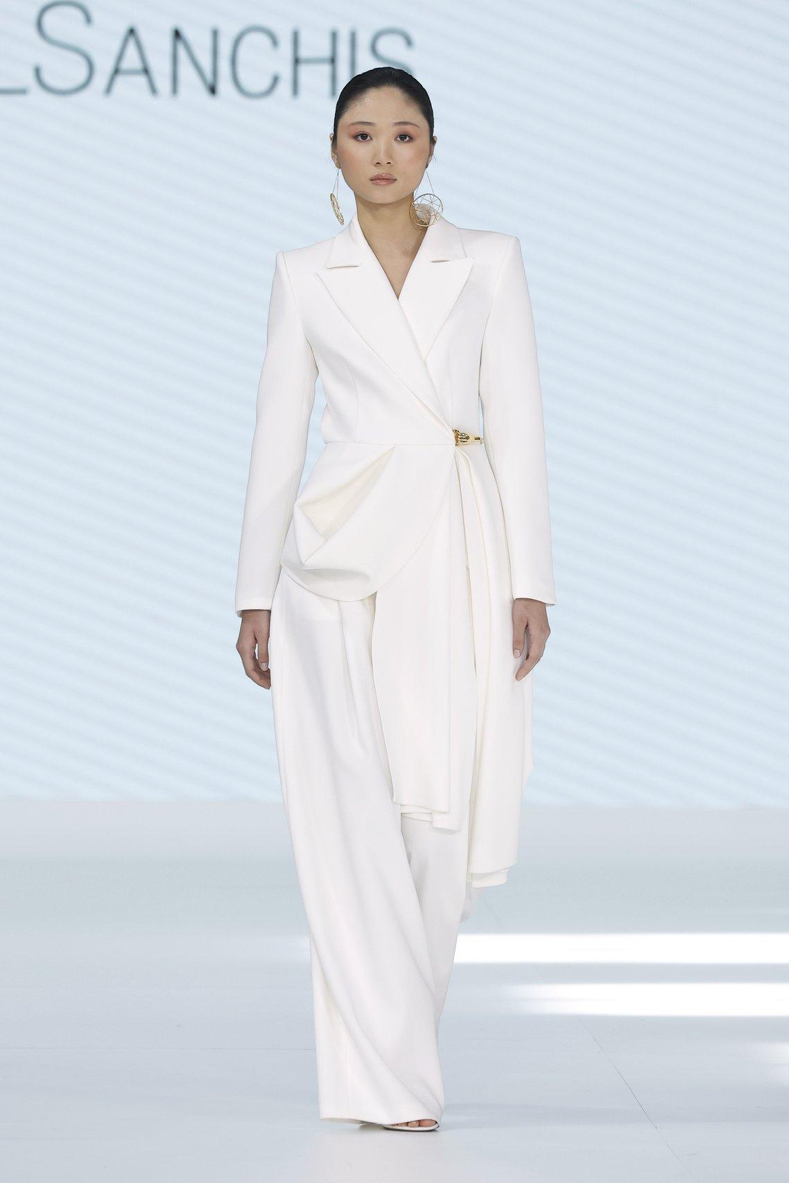 Model wearing a structured white blazer with gold hardware by Isabel Sanchis at Barcelona Bridal Week 