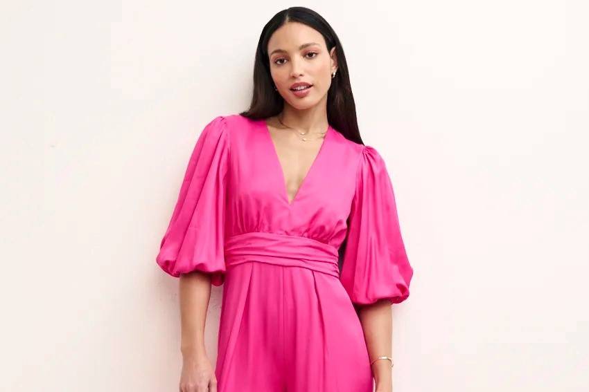 Model wearing a hot pink puff sleeve jumpsuit