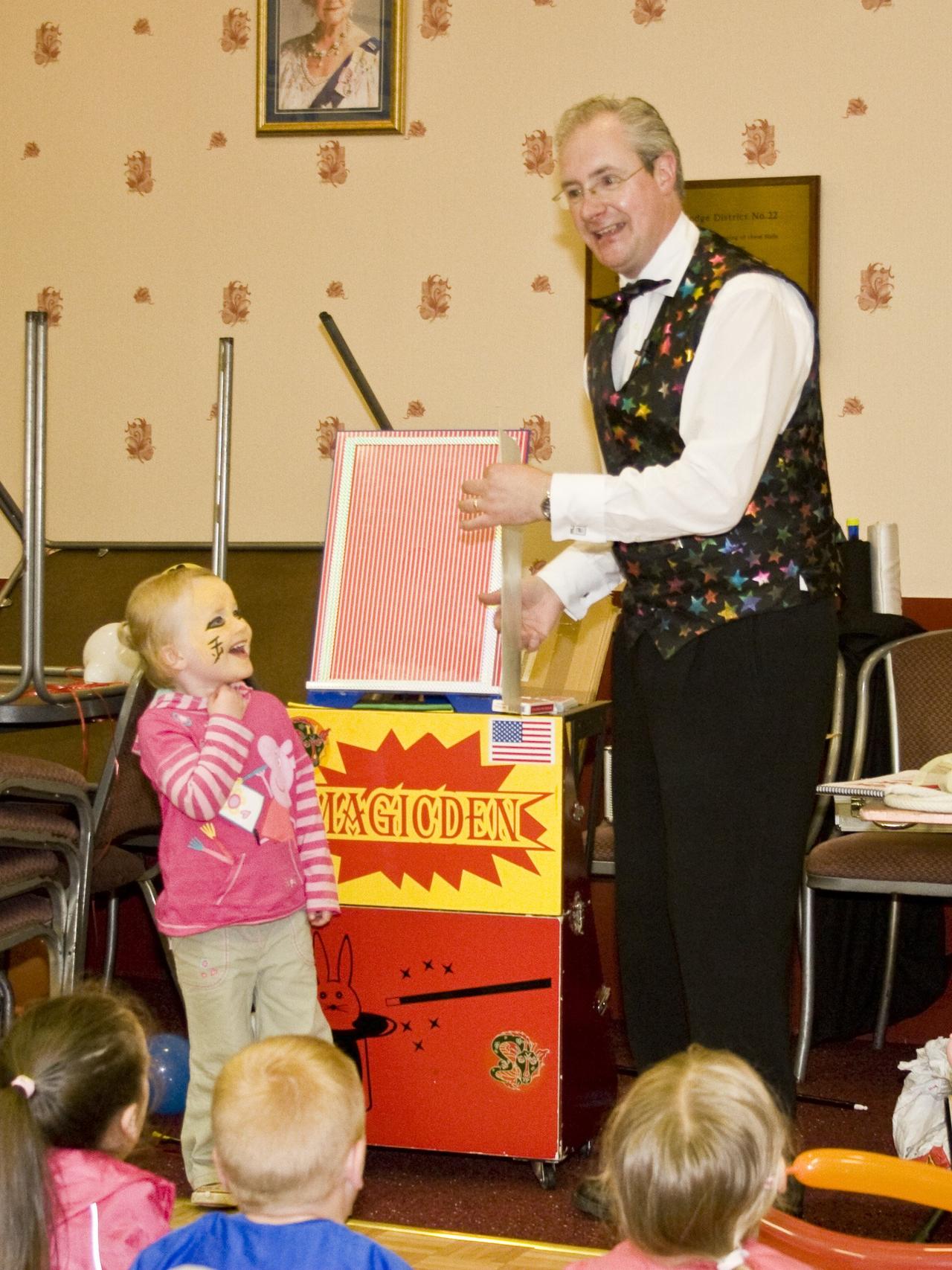 A magician entertaining a small child with a magic trick